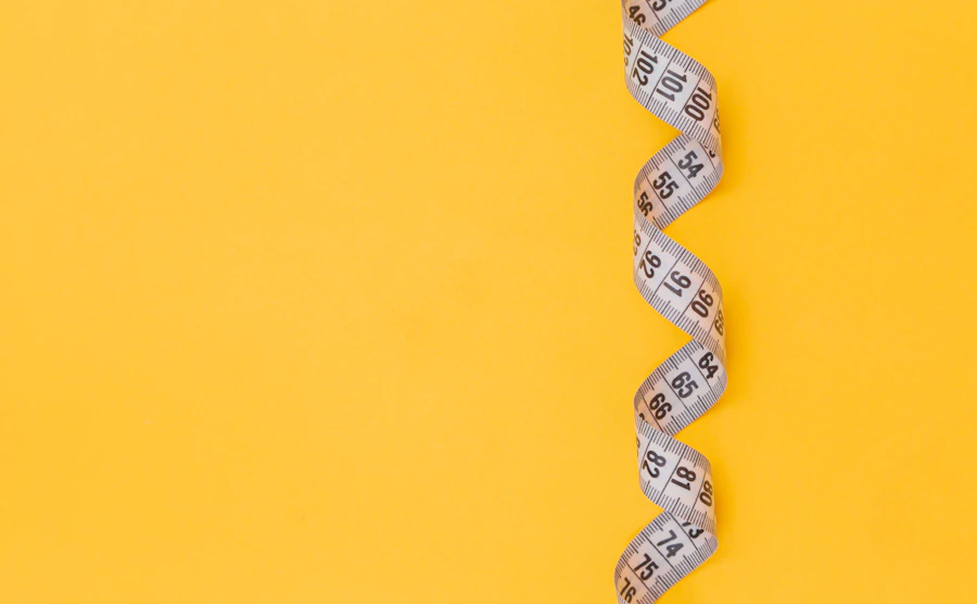 A measuring tape coiled like a snake on a yellow background