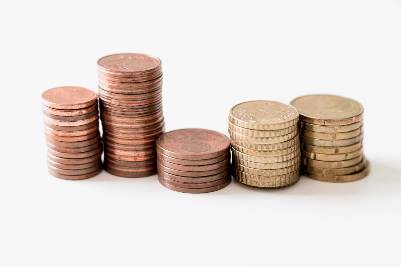 Stacks of gold coins on a white surface